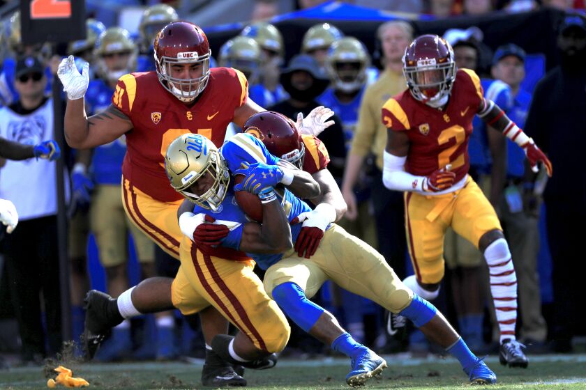 LOS ANGELES, CALIFORNIA - NOVEMBER 23: Olaijah Griffin #2, Marlon Tuipulotu #51 and Brandon Pili #91 of the USC Trojans tackle Joshua Kelley #27 of the UCLA Bruins during the first half of a game at Los Angeles Memorial Coliseum on November 23, 2019 in Los Angeles, California. (Photo by Sean M. Haffey/Getty Images)