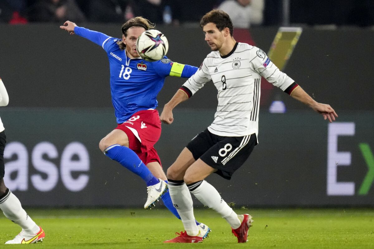 Germany's Leon Goretzka, right, and Liechtenstein's Nicolas Hasler challenge for the ball during the World Cup 2022 group J qualifying soccer match between Germany and Liechtenstein in Wolfsburg, Germany, Thursday, Nov. 11, 2021. (AP Photo/Michael Sohn)