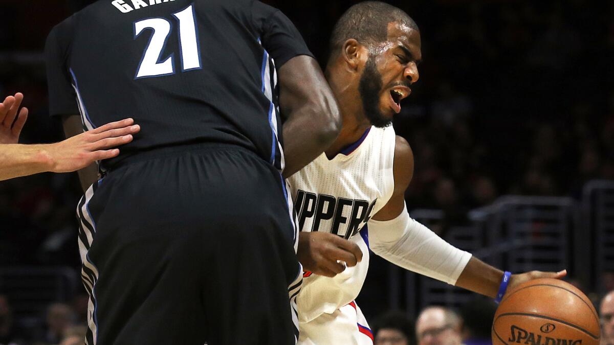 Clippers point guard Chris Paul reacts after colliding with Timberwolves forward Kevin Garnett on a drive in the first half Sunday.