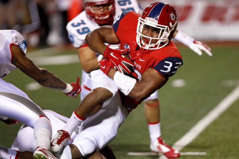 Fresno State running back Marteze Waller works for extra yards and a first down after contact against New Mexico on Friday night.