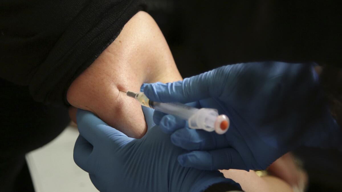 A woman receives a measles, mumps and rubella vaccine.