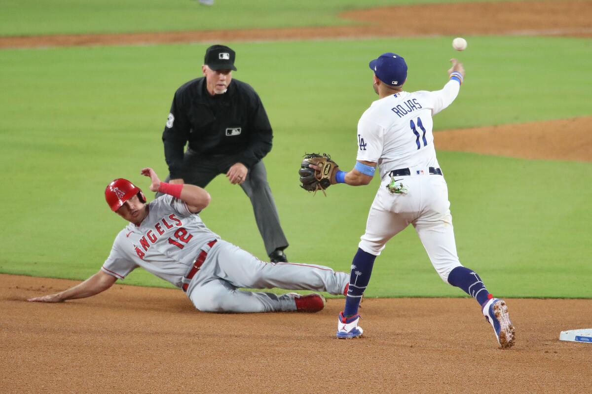 Angels first baseman Hunter Renfroe is out at second as Dodgers shortstop Miguel Rojas throws to first.
