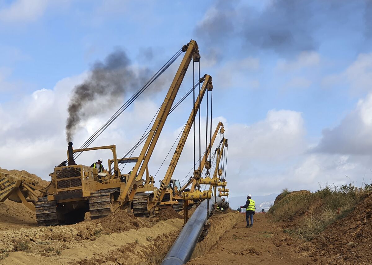 Heavy machinery installing a pipeline