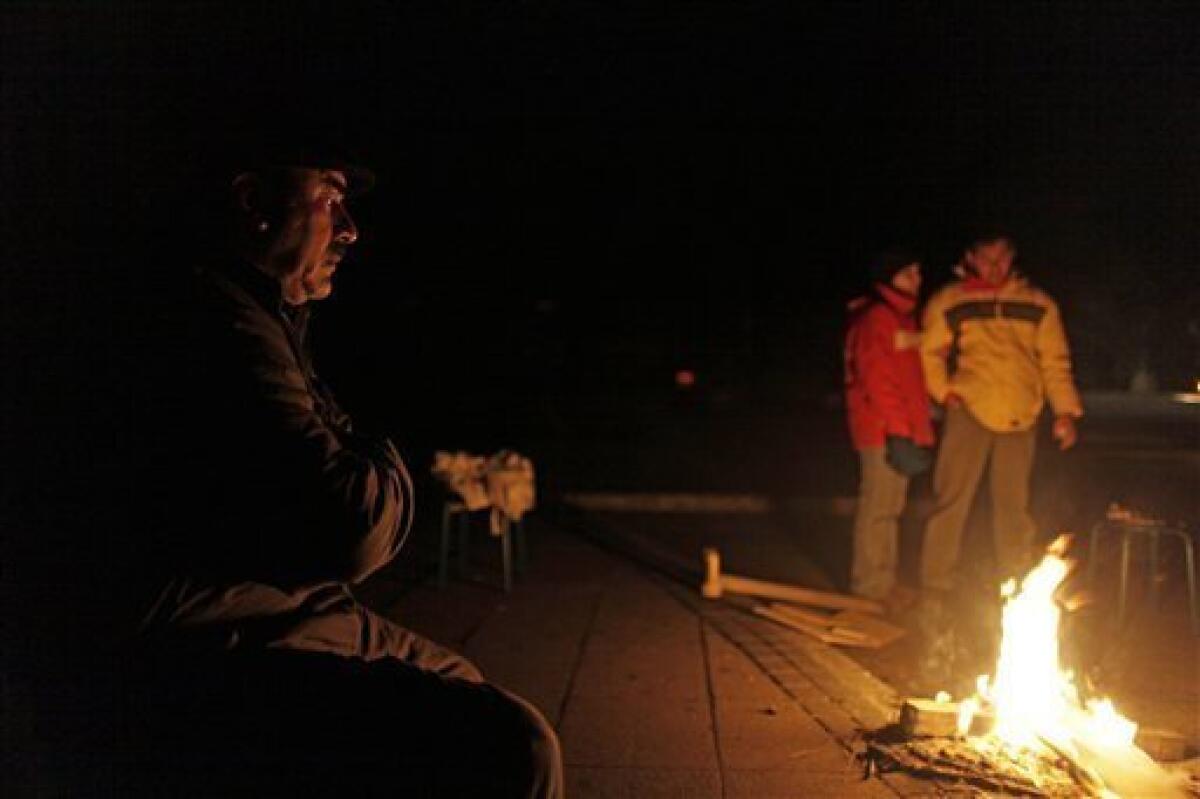 People gather around a fire on a street fearful of being inside because of after shocks in Concepcion, Sunday, Feb. 28, 2010, following a devastating earthquake struck Chile early Saturday Feb. 27, 2010. (AP Photo/ Natacha Pisarenko)