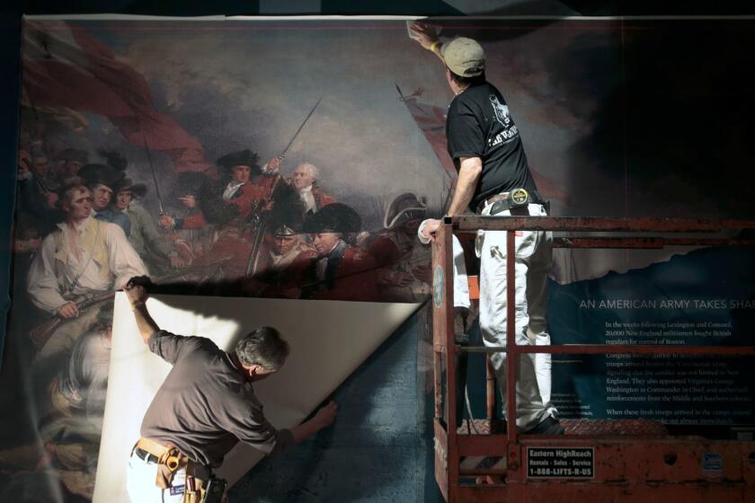 Gary Davis, left, and Paul Synnamon hang a mural depicting the Battle of Bunker Hill as construction continues at the Museum of the American Revolution in Philadelphia.