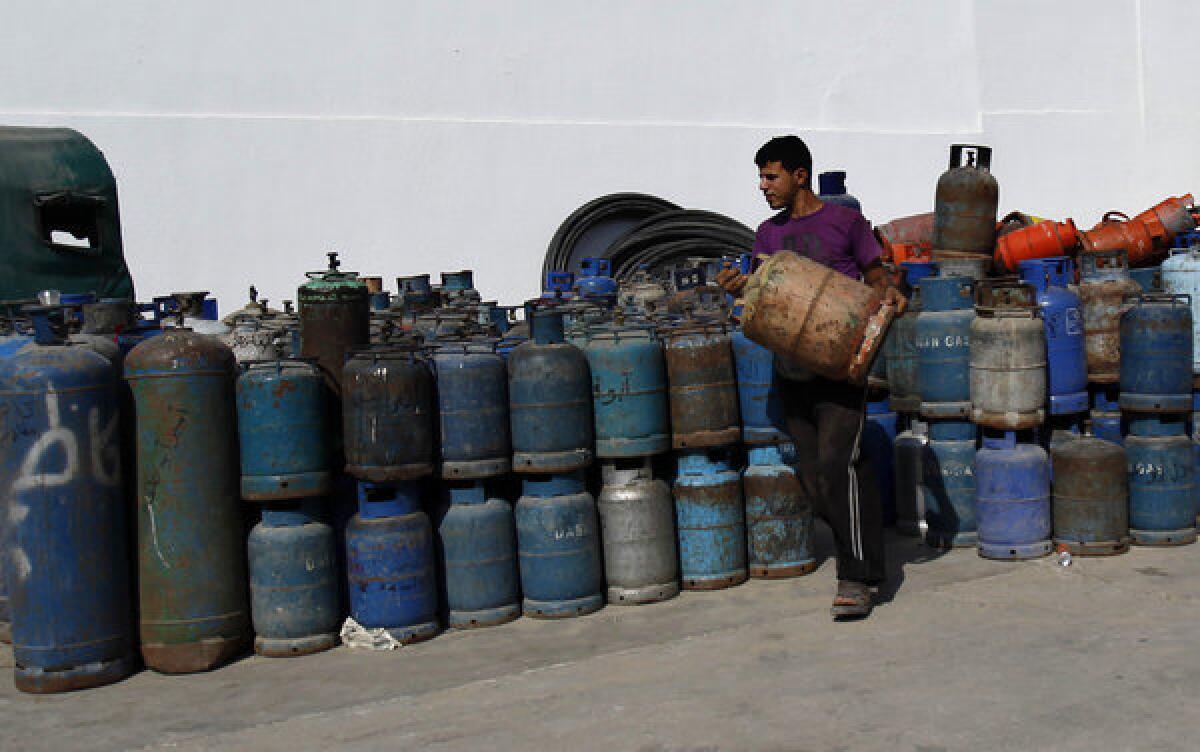 A Palestinian worker carries a cooking gas cylinder in Gaza City this month.