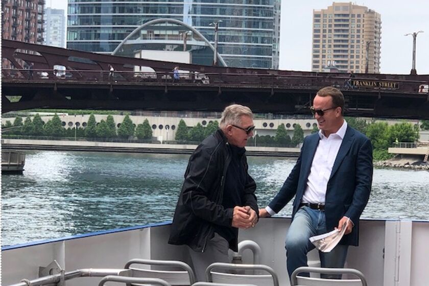 Peyton Manning, right, hangs out with legendary Bears coach Mike Ditka on the Chicago River as part of Manning's ESPN+ documentary series on the NFL's 100-year history.