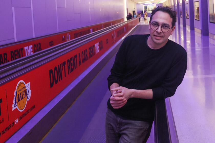 Los Angeles, CA - January 18: Dublab Executive Director Alejandro Cohen poses for a portrait on the moving walkway at LAX on Thursday, Jan. 18, 2023 in Los Angeles, CA. Curated by the LA radio station Dublab, the orchestrina takes short original compositions from 30 LA composers and musicians and blends them into a seamless, ever-evolving ambient soundtrack for traveling between gates in a new pedestrian tunnel. (Michael Blackshire / Los Angeles Times)