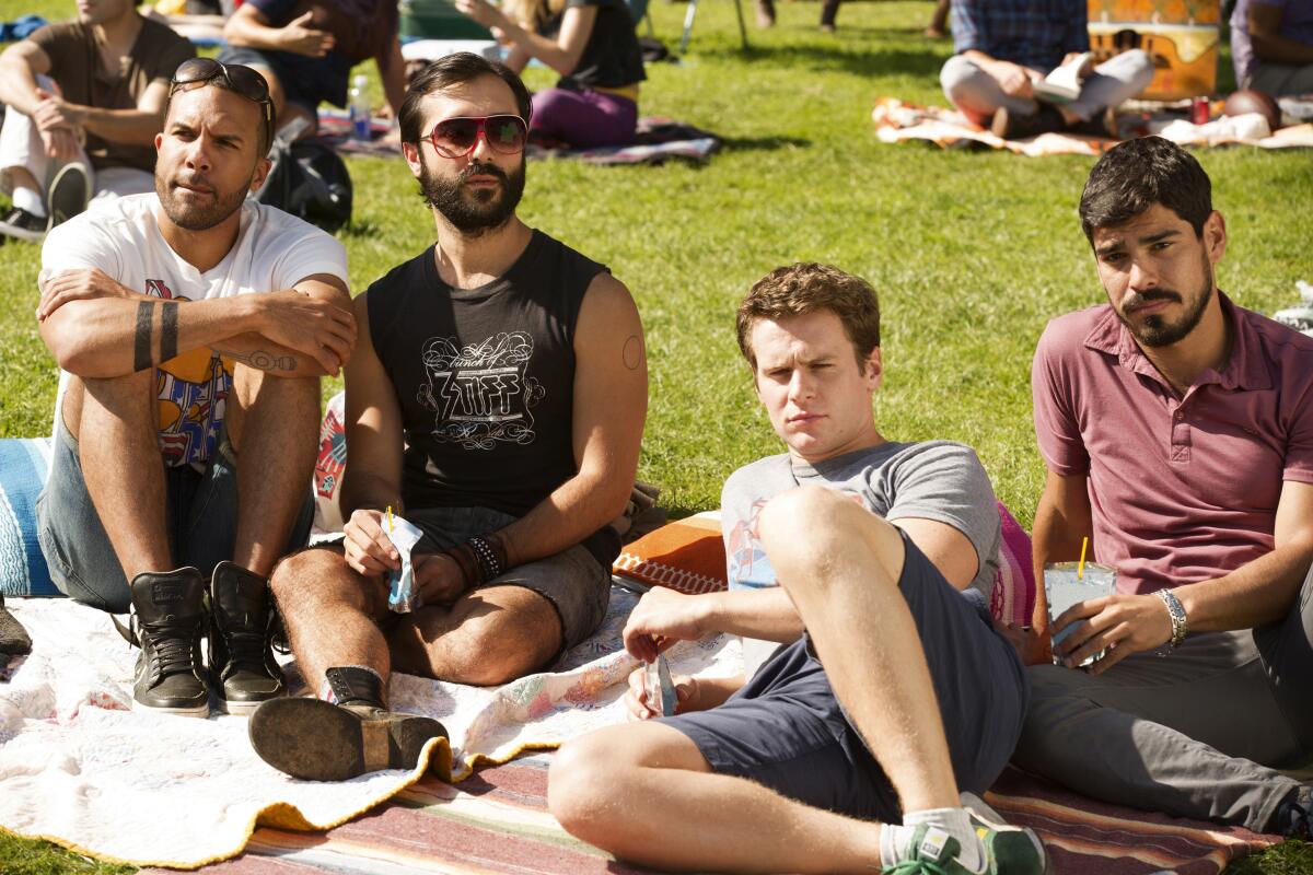 A group of men sit in the park together.
