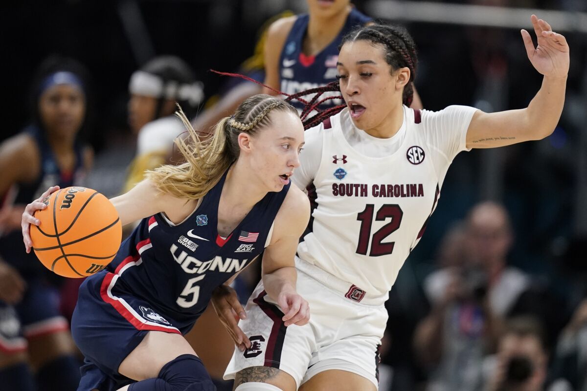 UConn's Paige Bueckers tries to get past South Carolina's Brea Beal during the first half of a college basketball game in the final round of the Women's Final Four NCAA tournament Sunday, April 3, 2022, in Minneapolis. (AP Photo/Charlie Neibergall)