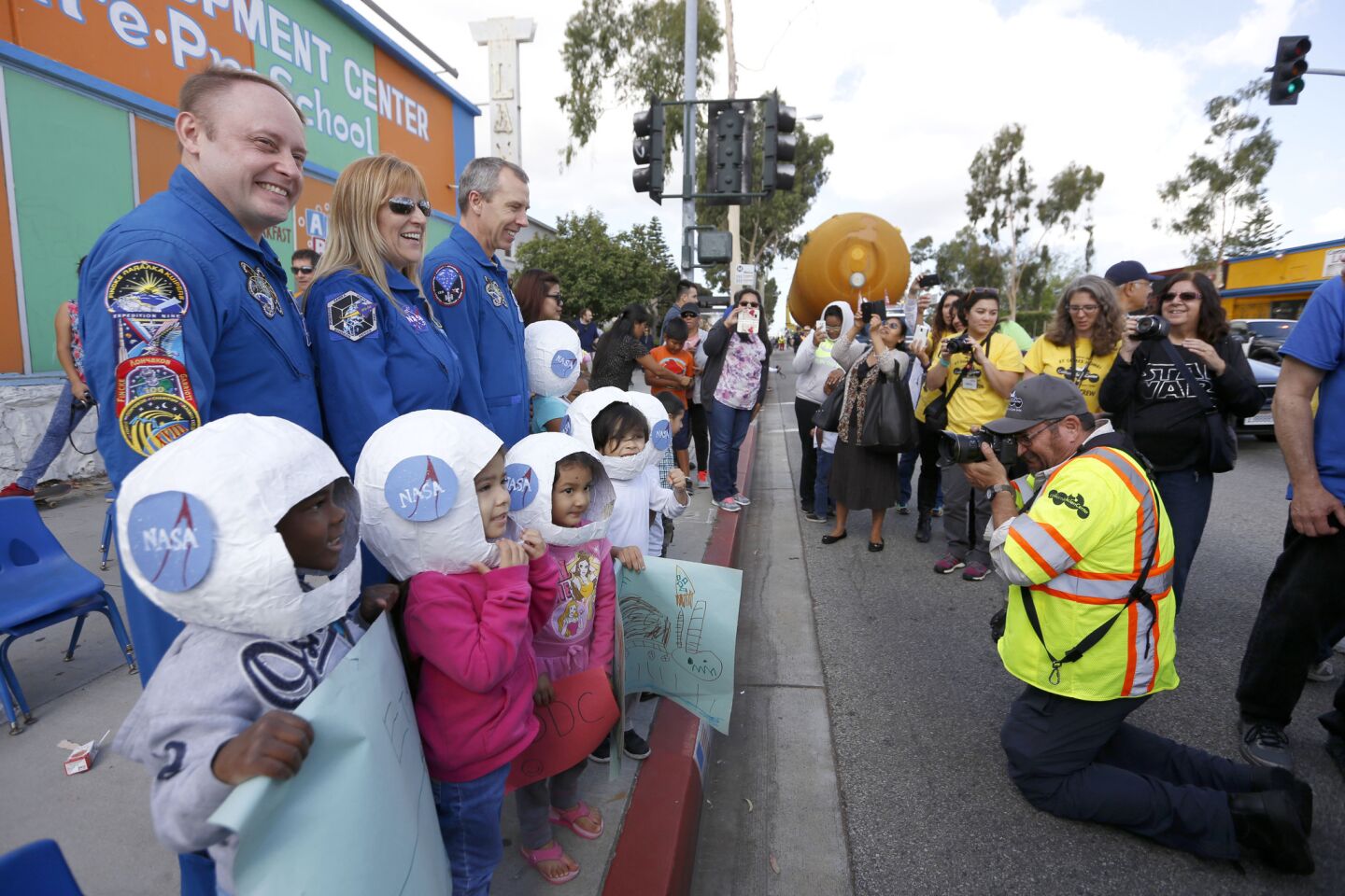 Astronauts pose with children as ET-94, the giant orange external fuel tank, is en route to the California Science Center on Saturday.