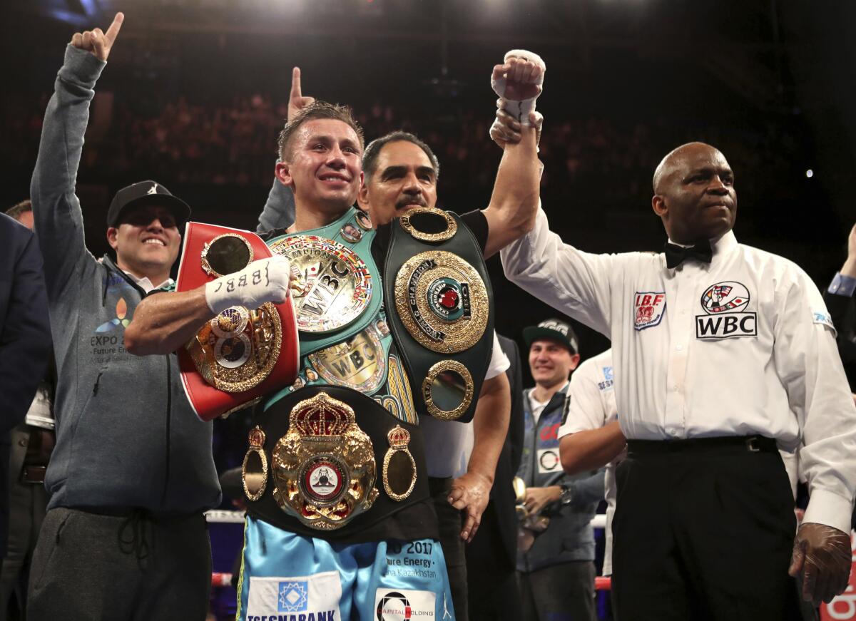 El kazajo Gennady Golovkin posa con sus cinturones de campeón de los medianos CMB-FIB-OIB, luego de vencer al británico Kell Brook, en Londres.