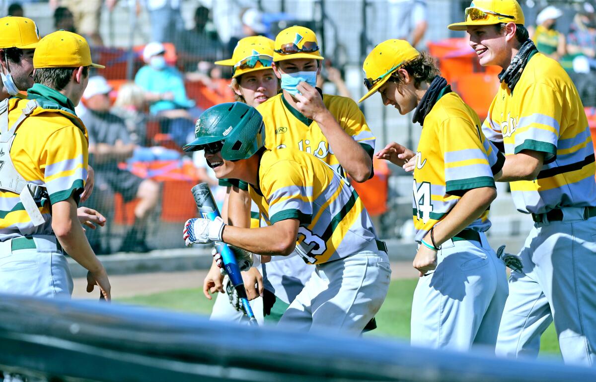 Edison's Logan Hamrick, center, is congratulated after scoring a run in a game vs. Huntington Beach on Wednesday.