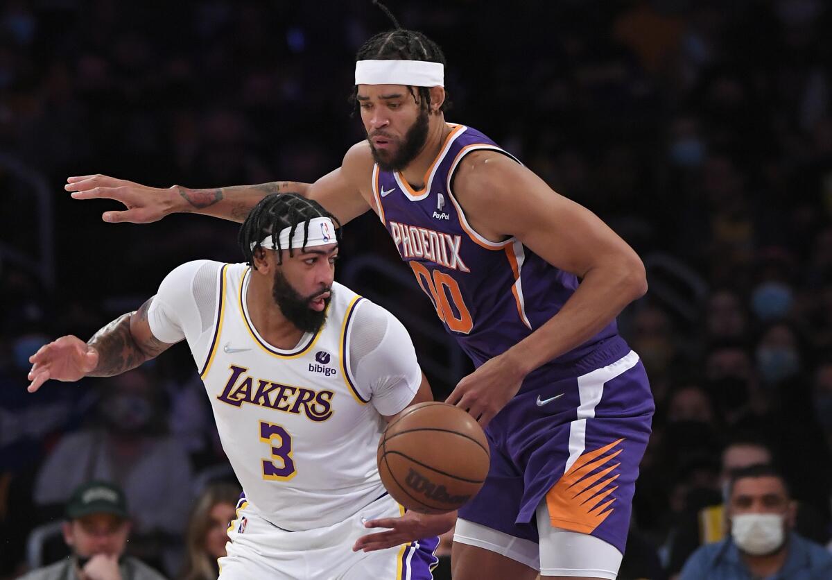 Lakers forward Anthony Davis and Phoenix Suns center JaVale McGee battle for the ball.