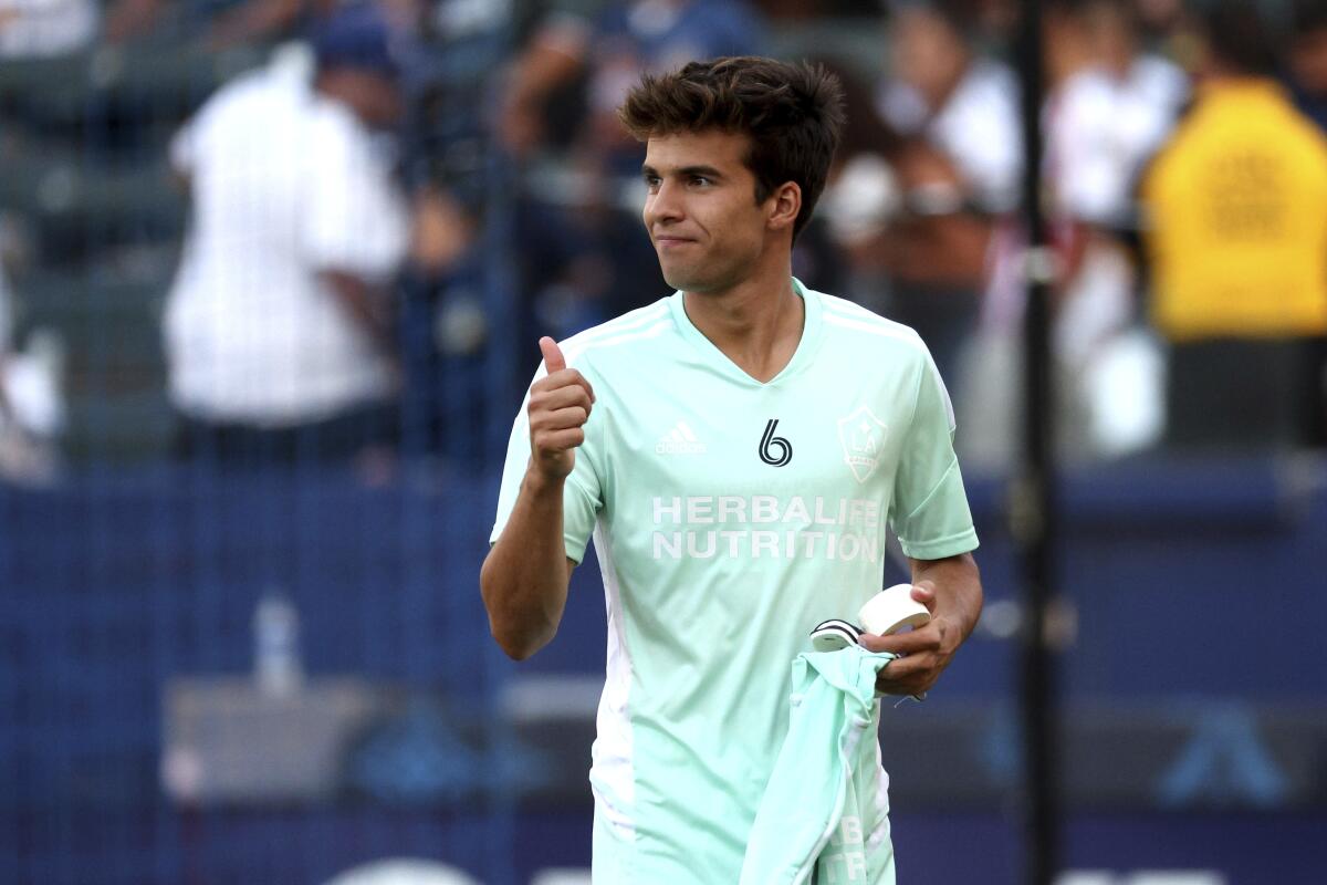 LA Galaxy midfielder Riqui Puig gestures to fans before an MLS soccer match.