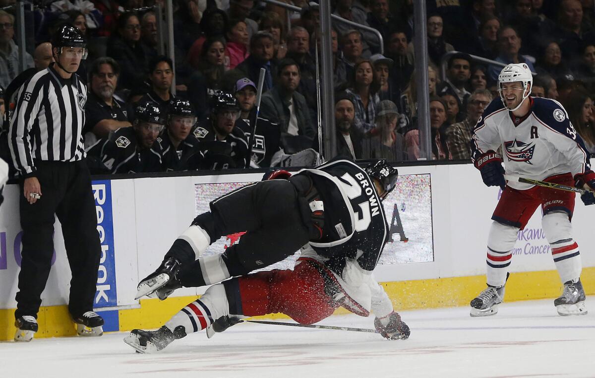 Kings forward Dustin Brown (23) takes down Blue Jackets center Lukas Sedlak (45) in the second period on Oct. 25.
