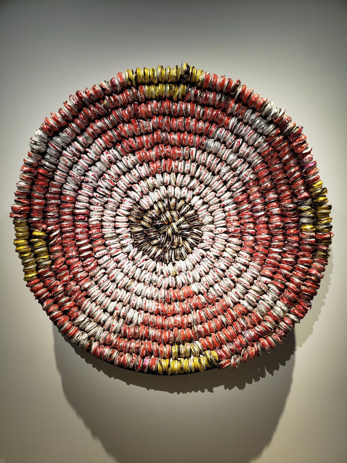 Hundreds of crushed beer and soda cans in a spiral pattern.