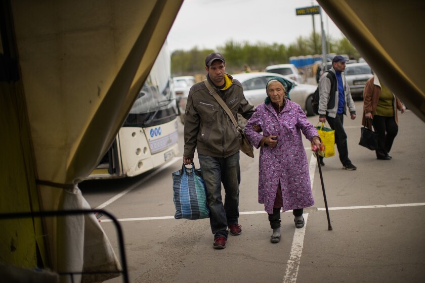 Kateryna Hodza, 85, and her grandson Artem Dorschenko arrive at a center for displaced people in Zaporizhzhia, Ukraine.