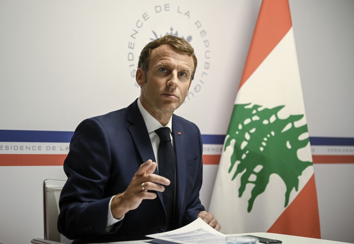 France's President Emmanuel Macron gestures as he attends an international video conference at the Fort de Bregancon, in Bormes-Les-Mimosas, southern France, Wednesday, Aug. 4, 2021. The virtual event, co-hosted by France and the United Nations, is meant to show support towards Lebanese people, French President Emmanuel Macron said. France will provide 100 millions euros ($118.6 million) in the coming months, Macron said in his opening remarks. (Christophe Simon/Pool Photo via AP)