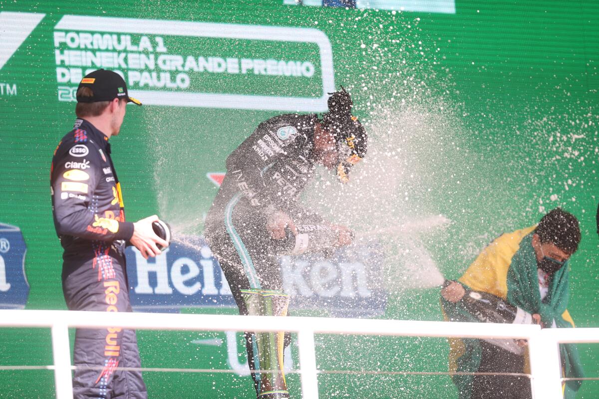 Red Bull driver Max Verstappen, of The Netherlands, left, Mercedes driver Lewis Hamilton, of Britain, center, and Mercedes driver Valtteri Bottas, of Finland, celebrate their podium finish in the Brazilian Formula One Grand Prix at the Interlagos race track in Sao Paulo, Brazil, Sunday, Nov. 14, 2021. Hamilton came in first, Verstappen second and Bottas third. (Lars Baron, Pool Photo via AP)