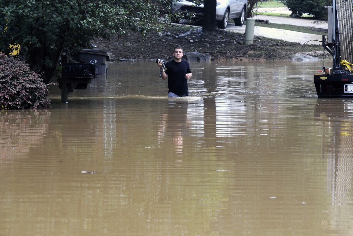 Michael Halbert wades through his flooded neighborhood in Pelham, Ala.