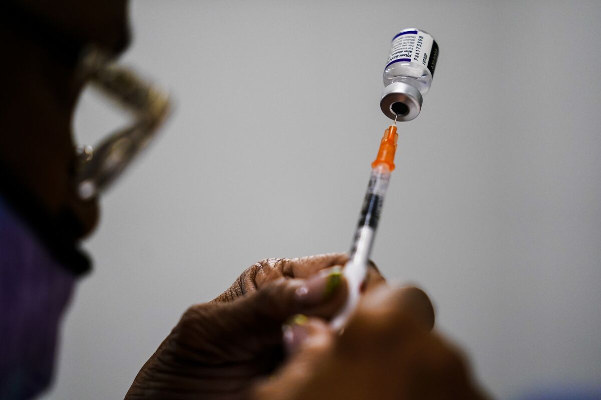 A syringe is prepared with a dose Pfizer COVID-19 vaccine at a vaccination clinic in Chester, Pa. 