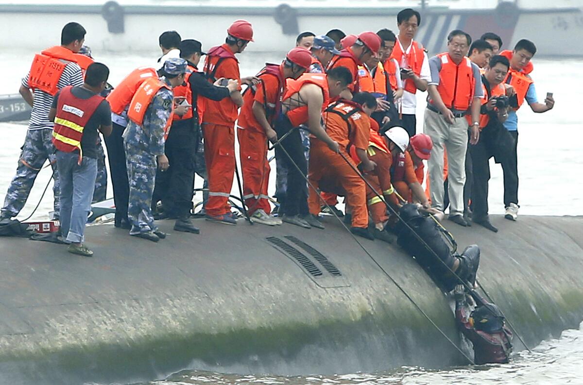 Rescatistas ayudan a sacar a un pasajero rescatado de un crucero naufragado en el río Yangtsé en el tramo de Jianli, en la provincia de Hubei, el martes 2 de junio de 2015. Los buzos sacaron el martes a varios sobrevivientes, dando un atisbo de esperanza en una tragedia de apariencia masiva con más de 400 desaparecidos en el río.