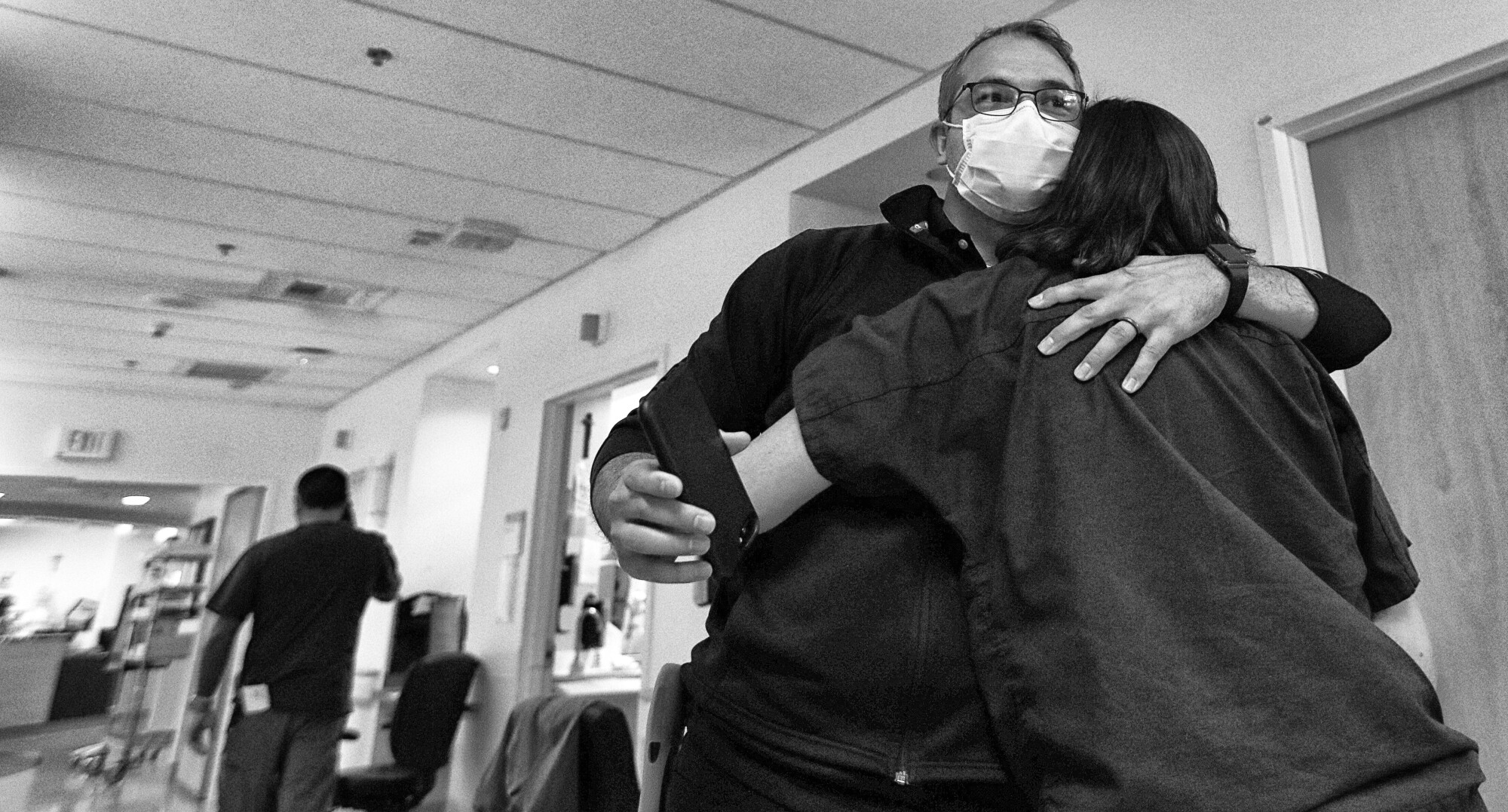 The fight against COVID, a chaplain says, unfolded on 'sacred ground' 14 Chaplain Kevin hugging a nurse in a hallway