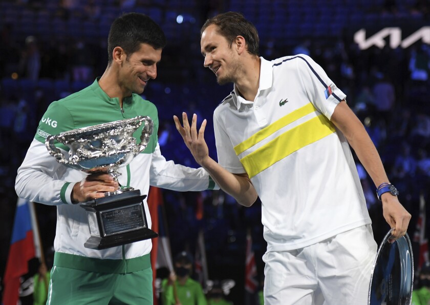 Serbia's Novak Djokovic, left, holds the Norman Brookes Challenge Cup as he talks with runner-up Russia's Daniil Medvedev after winning the men's singles final at the Australian Open tennis championship in Melbourne, Australia, Sunday, Feb. 21, 2021.(AP Photo/Andy Brownbill)