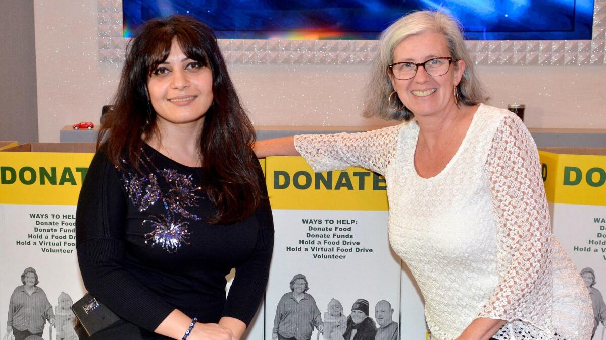 Schiff staff member Mary Hovagimian, left, joined Patricia Horton, who staged last week's holiday gathering, as food items were collected.