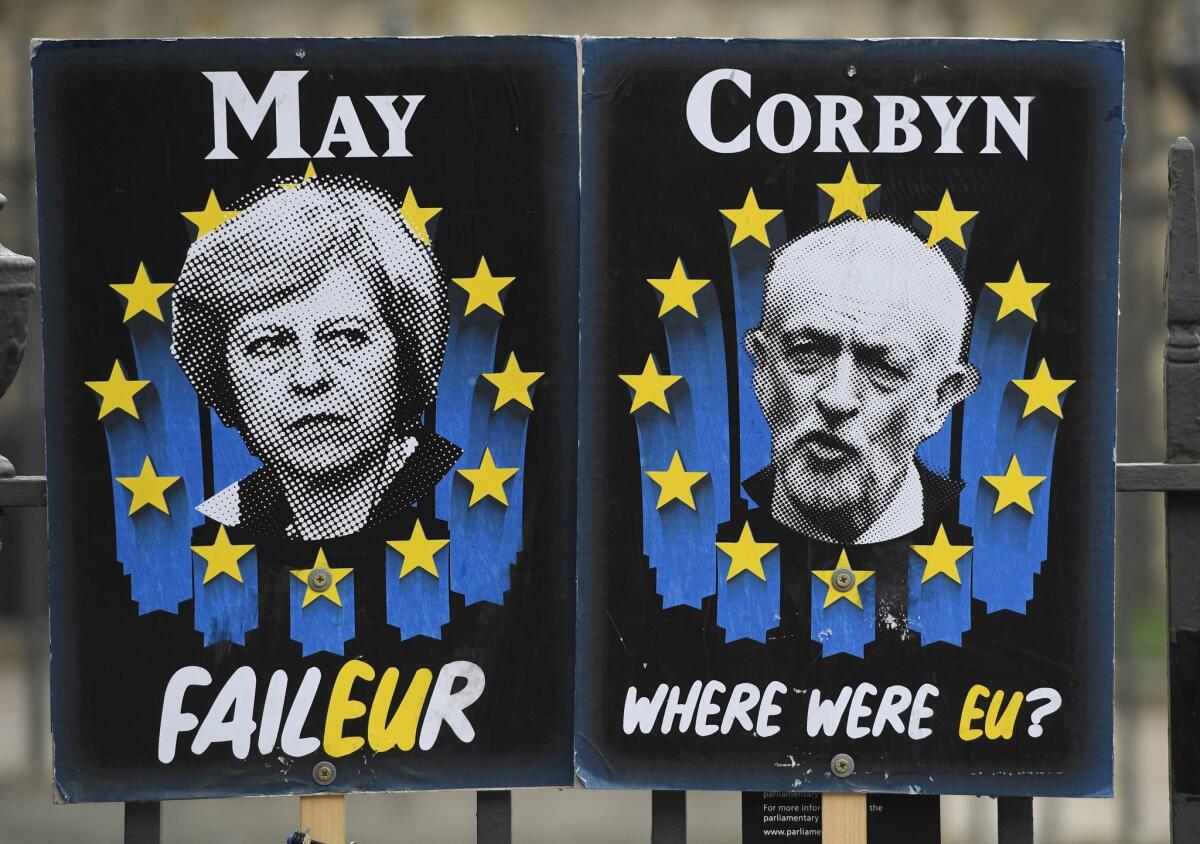 Posters mocking British politicians are set up outside the Houses of Parliament in London on Wednesday. Prime Minister Theresa May is expected to seek a deal with Labor Party leader Jeremy Corbyn to try to break the Brexit deadlock.