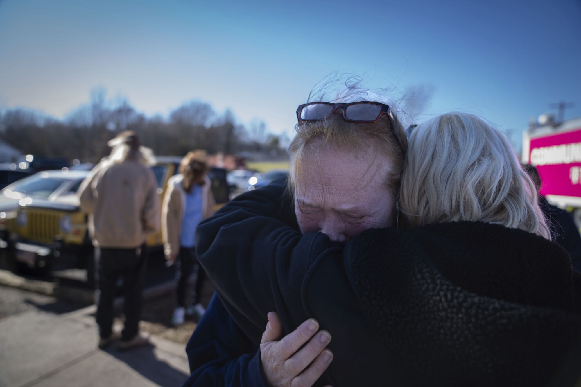 Tamara Yekinni hugs a friend outside a shelter in Wingo, Ky.