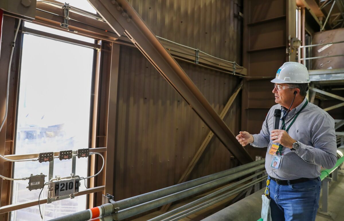 A man with a hard hat speaks into a microphone.