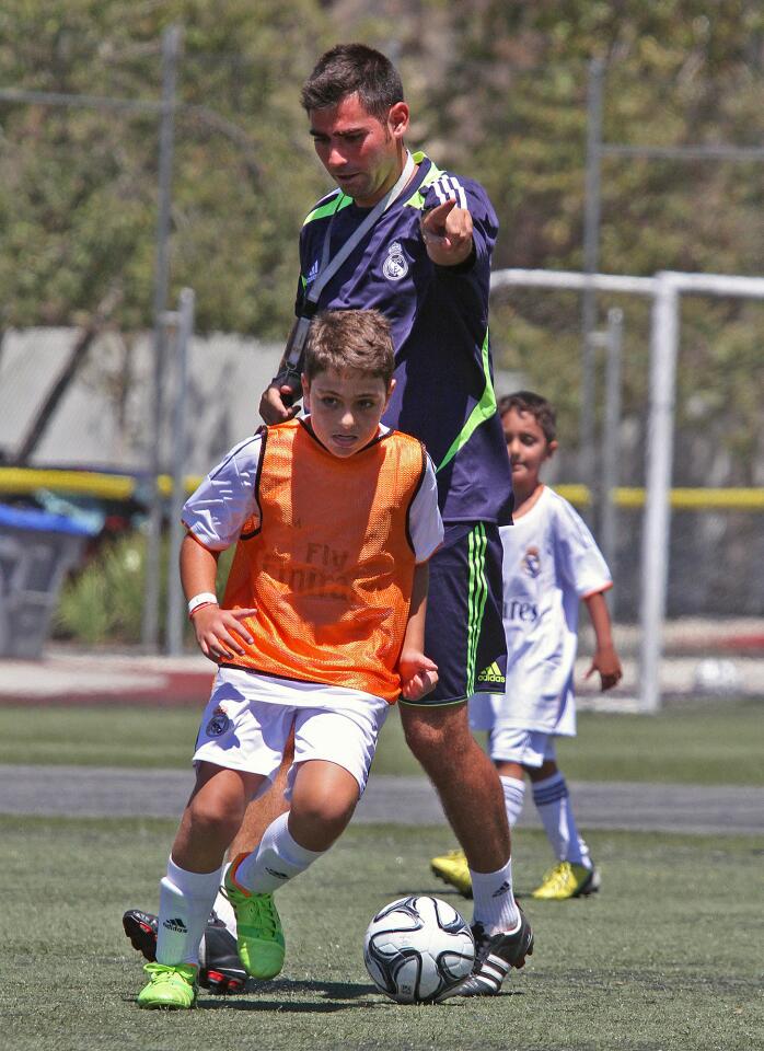 The Real Madrid Foundation Campus Experience Soccer camps coach Rafael Navarrete directs one of his campers during a scrimmage with Team Casillas, the youngest soccer campers at the Glendale Sports Complex on Tuesday, July 22, 2014. These camps, for soccer players from 7-17, are new and starting out in Southern California, the first of which at the Glendale Sports Complex.