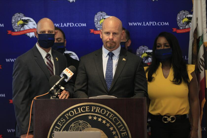 Jamie McBride, at podium, the outspoken leader of Los Angeles Police Protective League, LAPPL, the union that represents Los Angeles Police Department officers, comments on the leadership of Los Angeles Mayor Eric Garcetti, at a news conference Friday, June 5, 2020, at the LAPPL offices in Los Angeles. Mayor Garcetti is being pushed into unfamiliar roles in a city wracked by racial unrest, and his proposal to cut the police budget is seeing criticism from officers. The mayor said earlier this week city officials will identify as much as $150 million to slash from the Los Angeles Police Department budget. (AP Photo/Damian Dovarganes)