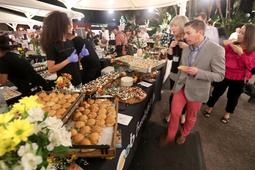 Guests sample offerings from an elaborate display from OEB Breakfast Co. during the Taste of Laguna at the Festival of Arts on Thursday.