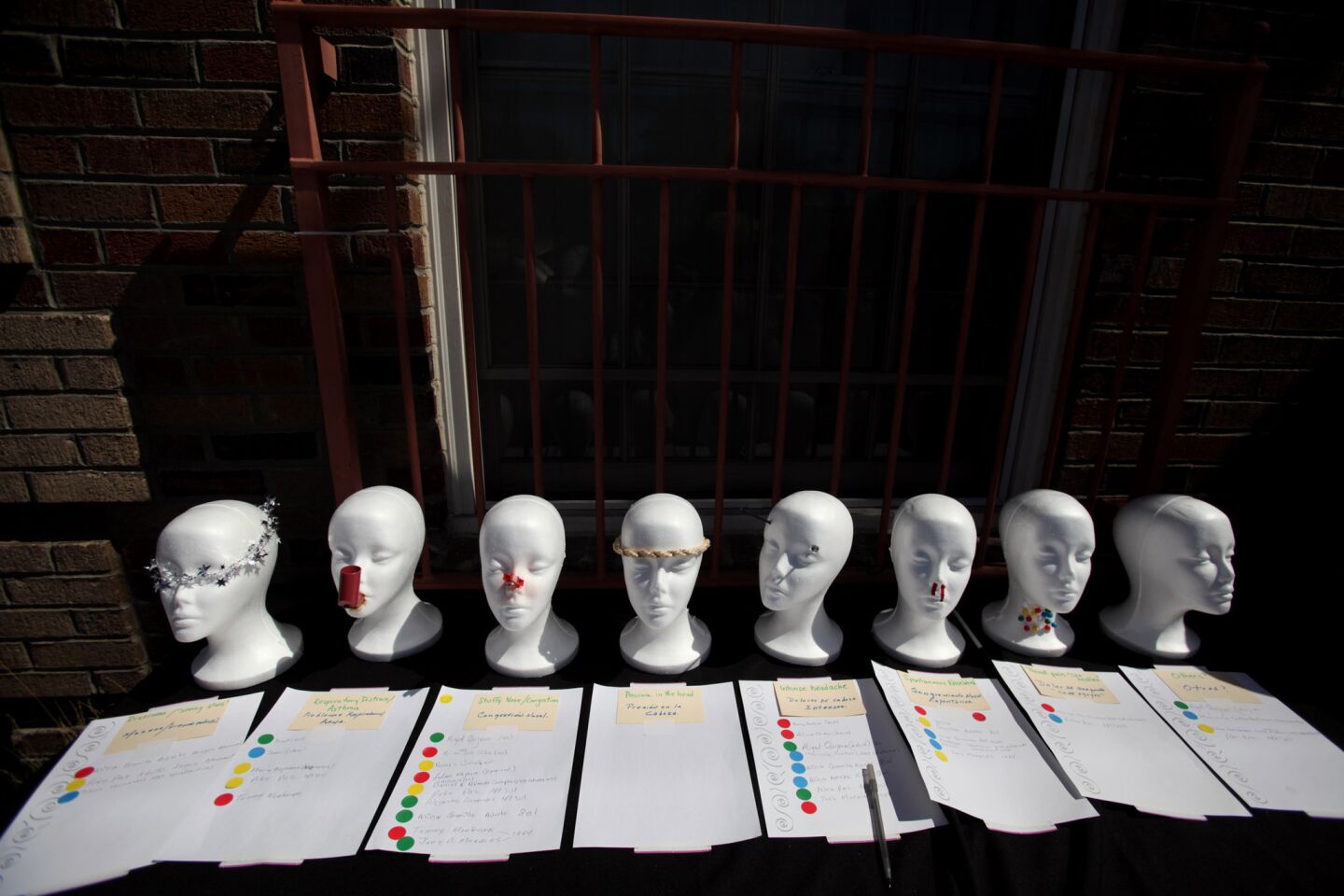 Residents were asked to sign their names on paper next to Styrofoam heads representing the various symptoms they were experiencing in the University Park neighborhood in Los Angeles.