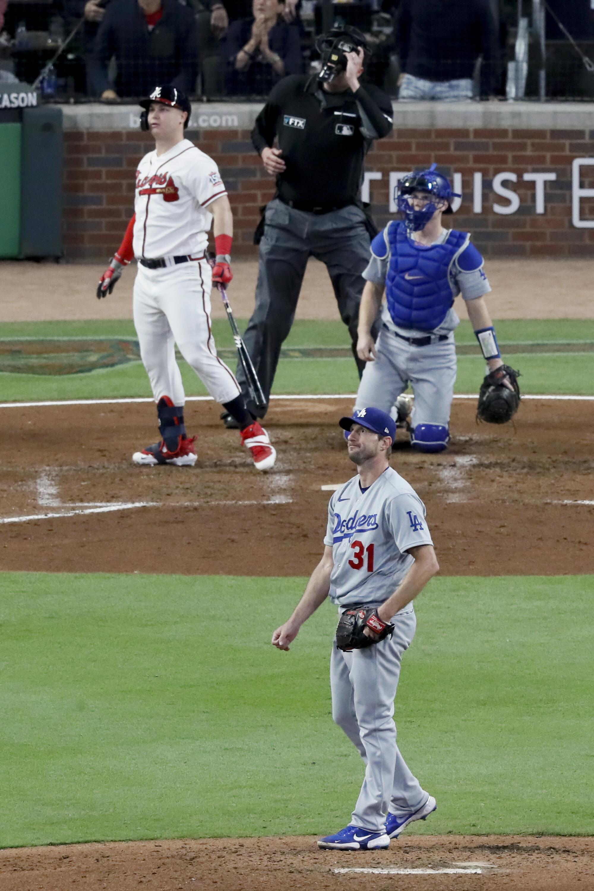 Dodgers starting pitcher Max Scherzer, bottom, looks up after allowing a two-run home run to Braves' Joc Pederson