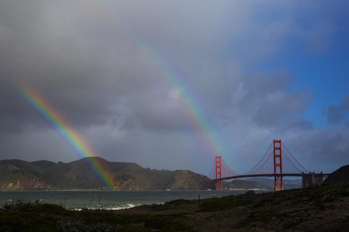 A double rainbow arches over the Golden Gate Bridge. 