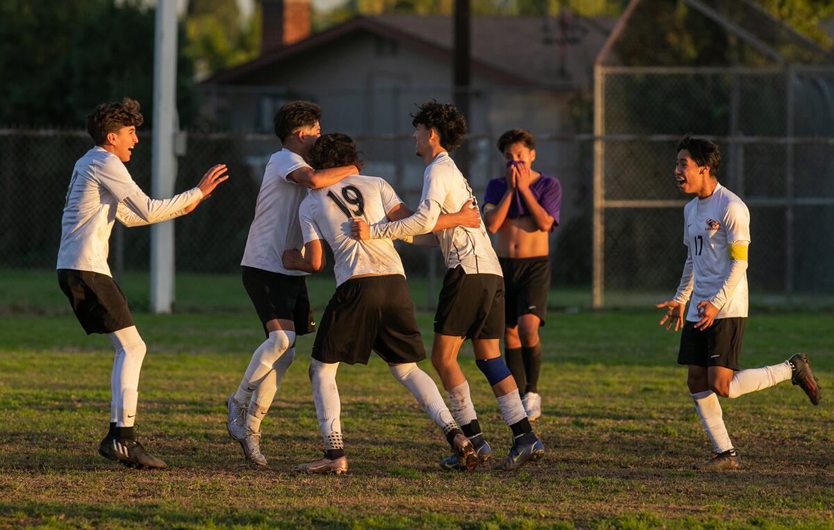 Los Amigos' Erubey Bermudez (19) is mobbed by his teammates after scoring the winning goal in overtime against Santiago.