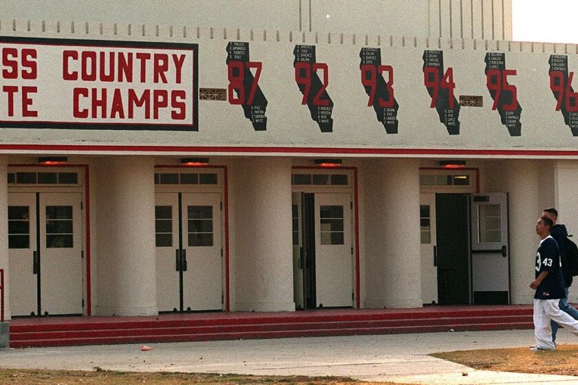 Painted emblems celebrating California championships are shown in this 1999 photo of the gym at McFarland High School.