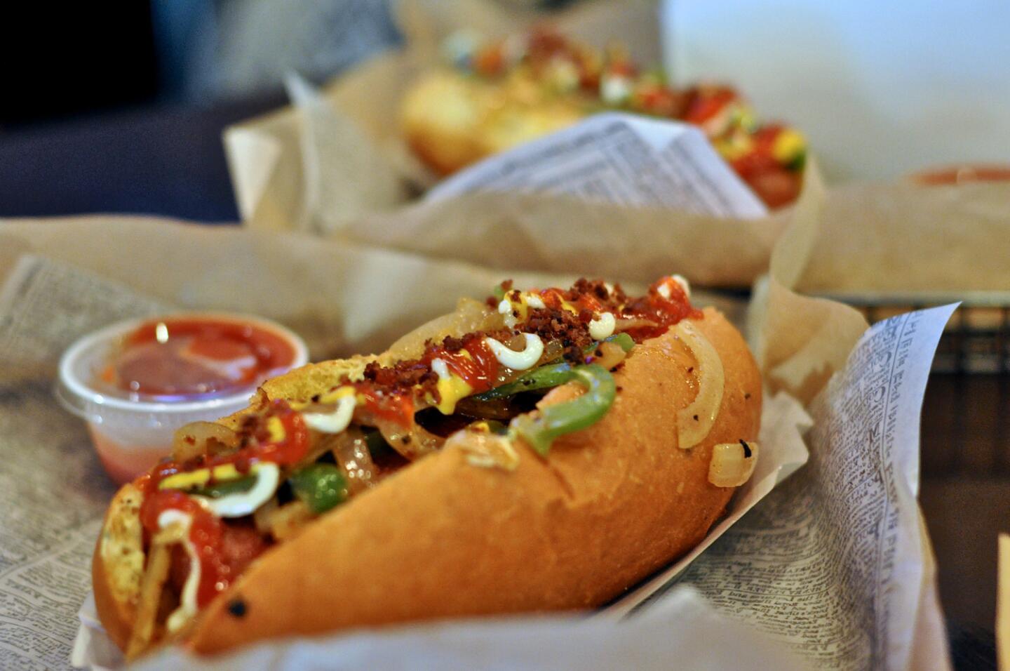 The House, or original, bacon-wrapped hot dog at Dirt Dog near USC comes loaded with grilled onions and peppers.