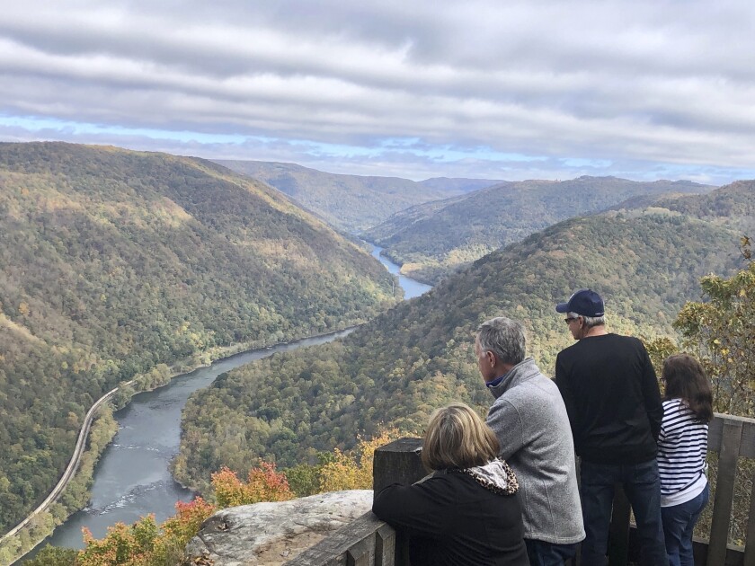 Visitors look down on the New River Gorge from a national park overlook Wednesday, Oct. 27, 2021, in Grandview, W.Va. Under legislation passed by Congress in 2020, some of America's most spectacular natural settings are getting a makeover. Historic masonry grills have been restored near the Grandview Visitor Center. (AP Photo/John Raby)