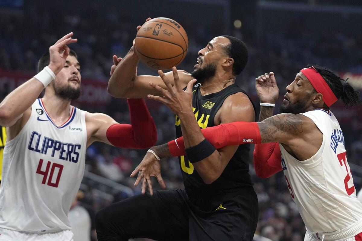 Utah Jazz guard Talen Horton-Tucker puts up a shot between Clippers center Ivica Zubac and forward Robert Covington.