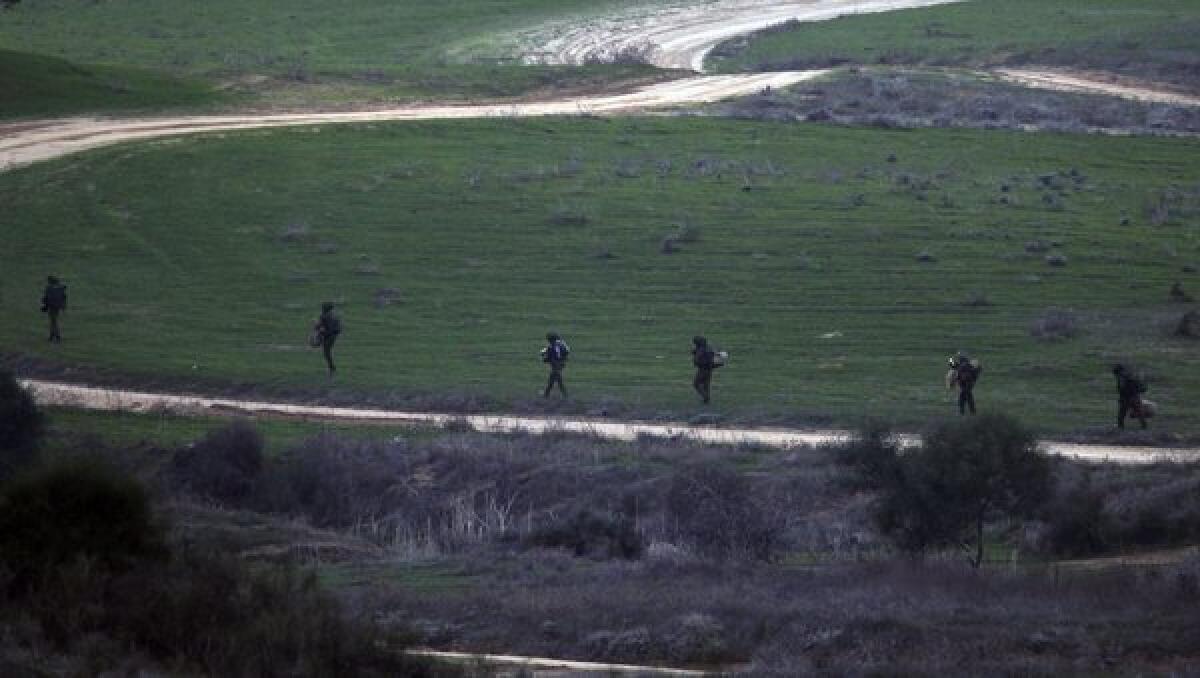 Israeli soldiers walk at dusk near the border with the Gaza Strip.