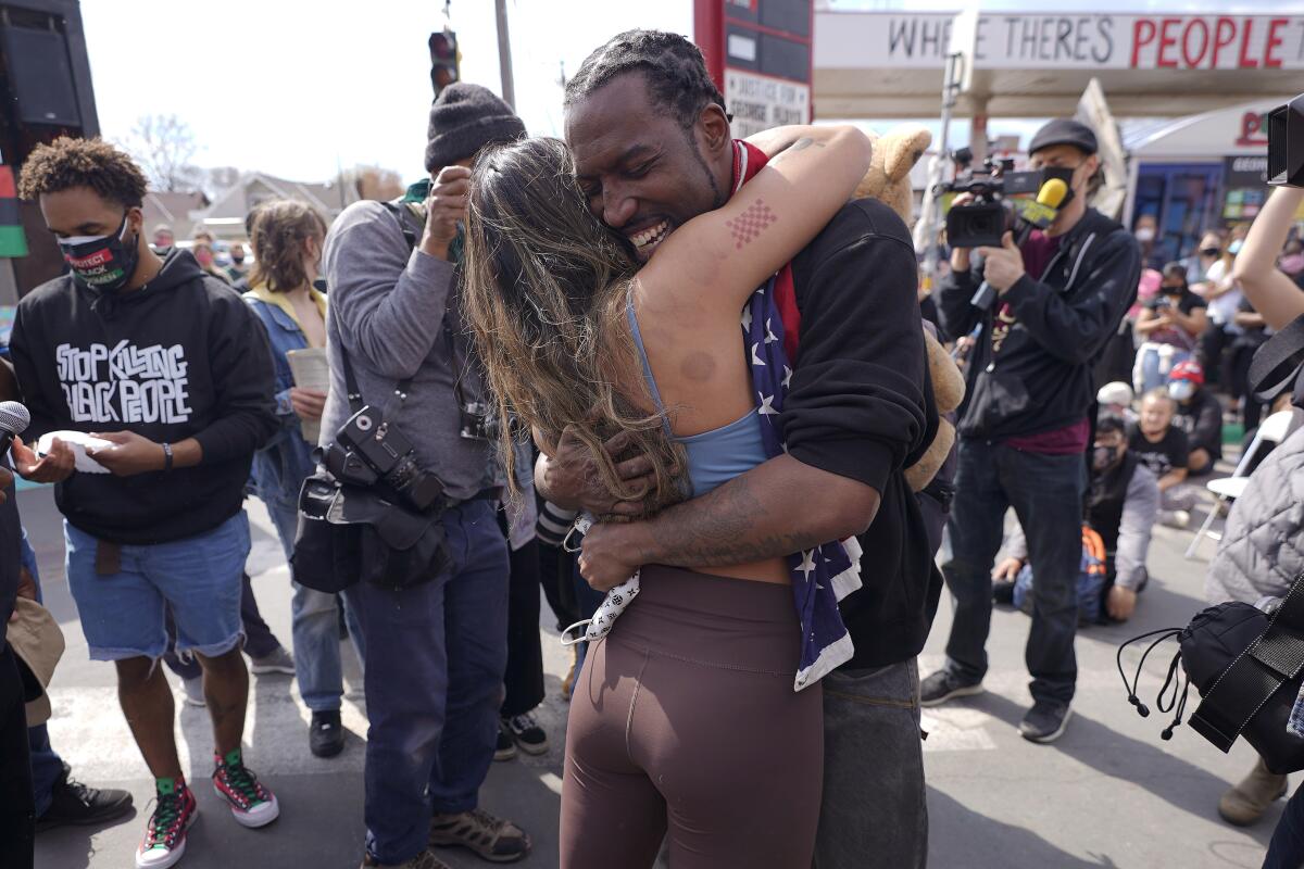 Michael Wilson abraza a la activista barrial Anthea Yur Kokoro durante un acto