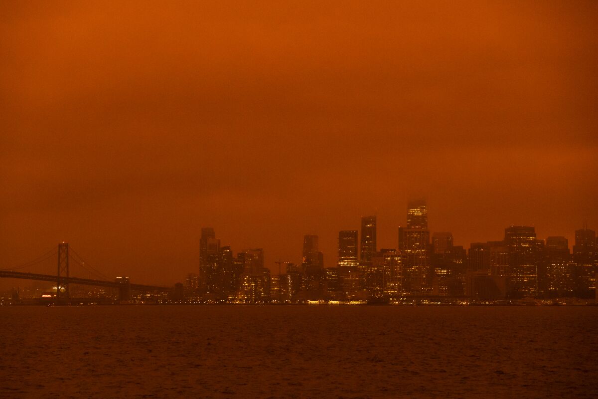The San Francisco skyline is shrouded in an orange haze