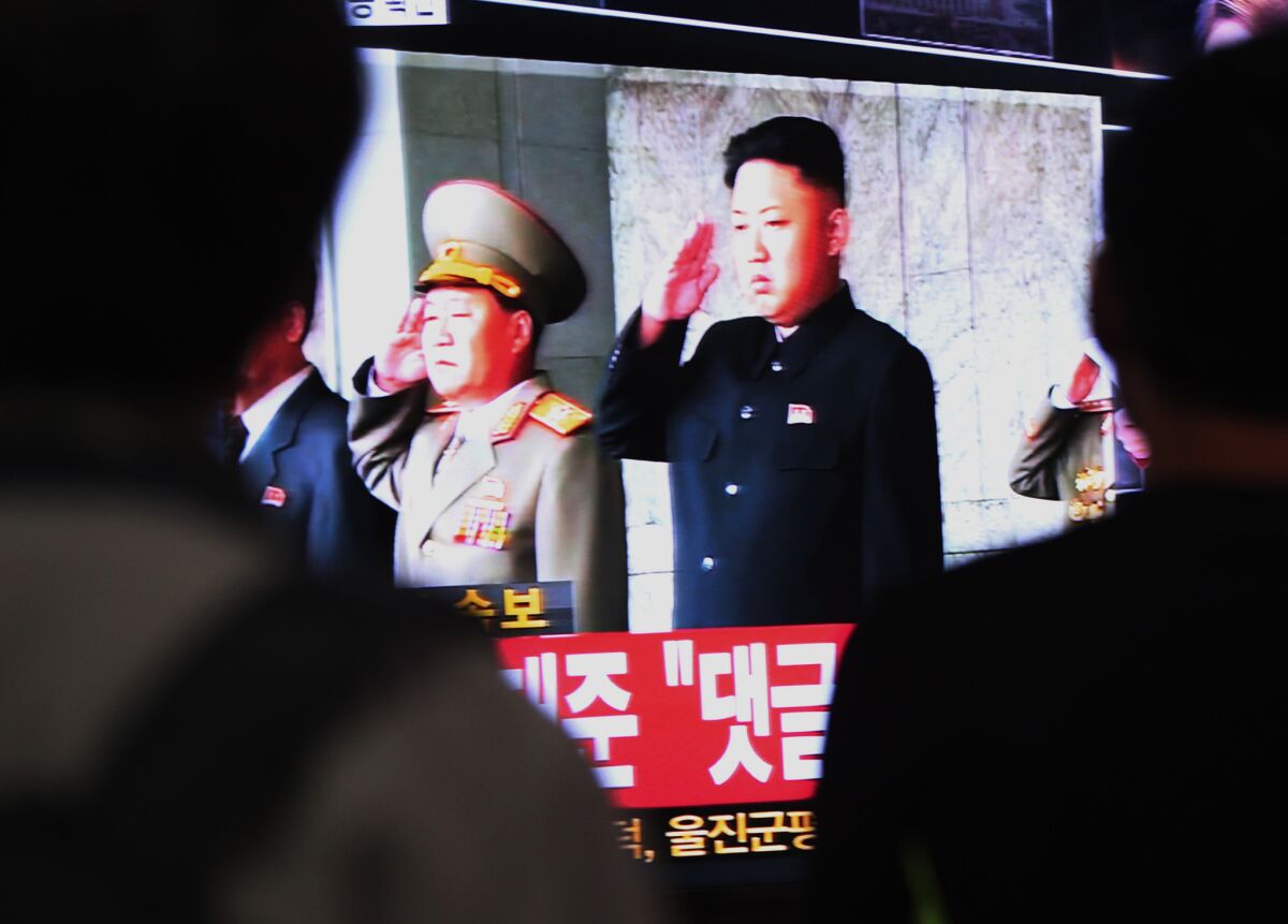 South Koreans watch a television broadcasting a video image of North Korean leader Kim Jong Un, right, at the Seoul Railway Station in South Korea.
