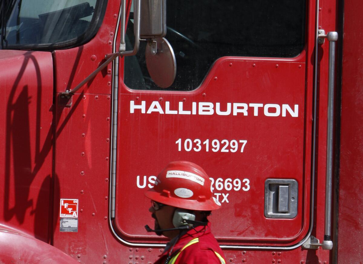 An unidentified worker passes a truck owned by Halliburton in Rulison, Colo., on April 15, 2009.