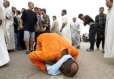 A freed Iraqi prisoner falls to his knees in prayer after his release from Abu Ghraib prison. He was one of about 600 prisoners released by the U.S. military on Friday.
